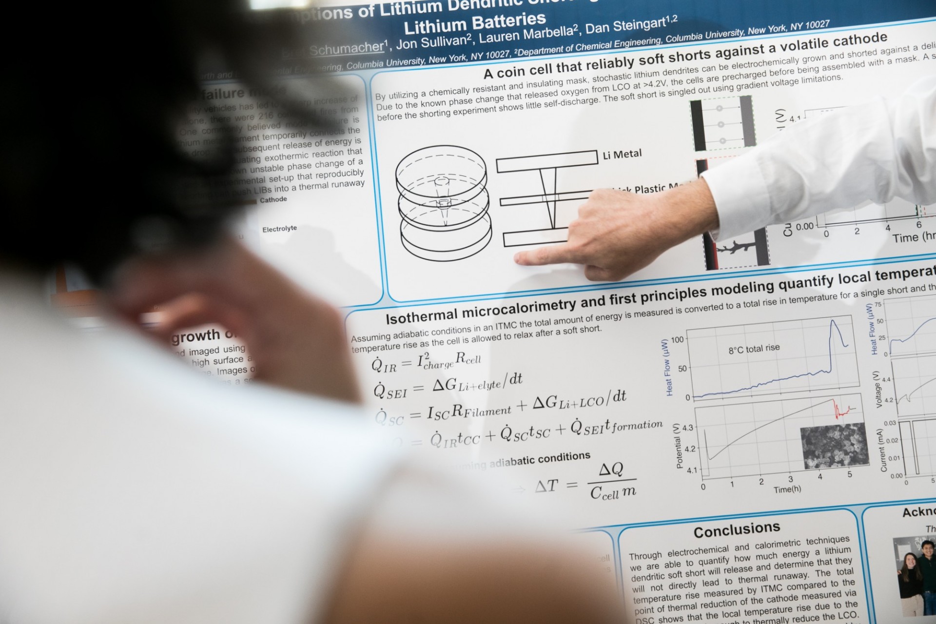 A finger points to new findings on a research poster